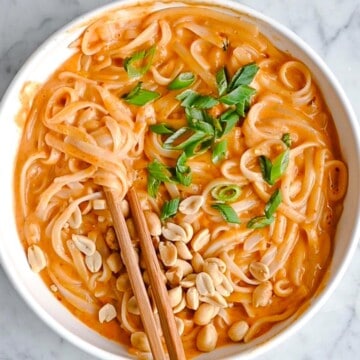 Thai Red Curry Noodles with chopped peanuts and scallions.