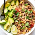Vegan Mexican Quinoa Bake paired with chopped avocado, and fresh lime. Garnished with chopped cilantro.
