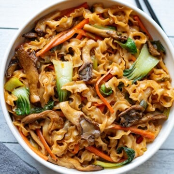 Guanmiao noodles, mushrooms, baby bok choy, carrots, green onions, and an Asian-inspired sauce. Mixed in a bowl for serving.