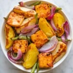 Orange-glazed tofu with roasted veggies in a white bowl for serving.