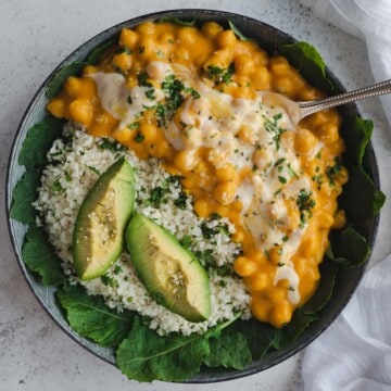 Creamy chickpea curry, cauliflower rice, baby kale, and avocado bowl.