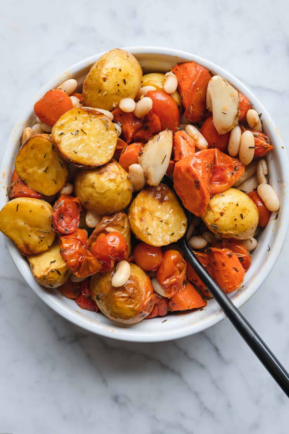 Roast potatoes, carrots, grape tomatoes, garlic, and white beans tossed with olive oil and fresh herbs.