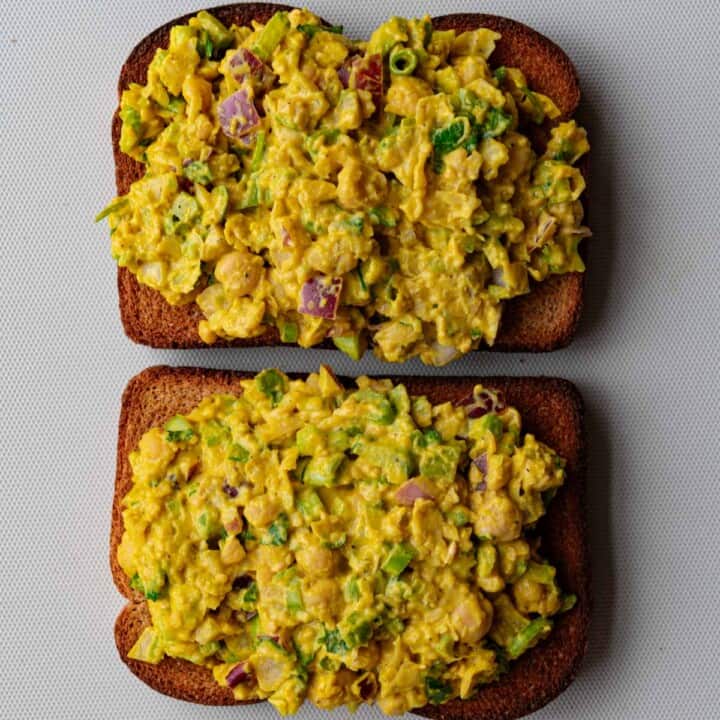 Curried chickpea salad with chopped red onion, celery, and scallions on two slices of whole wheat toast.