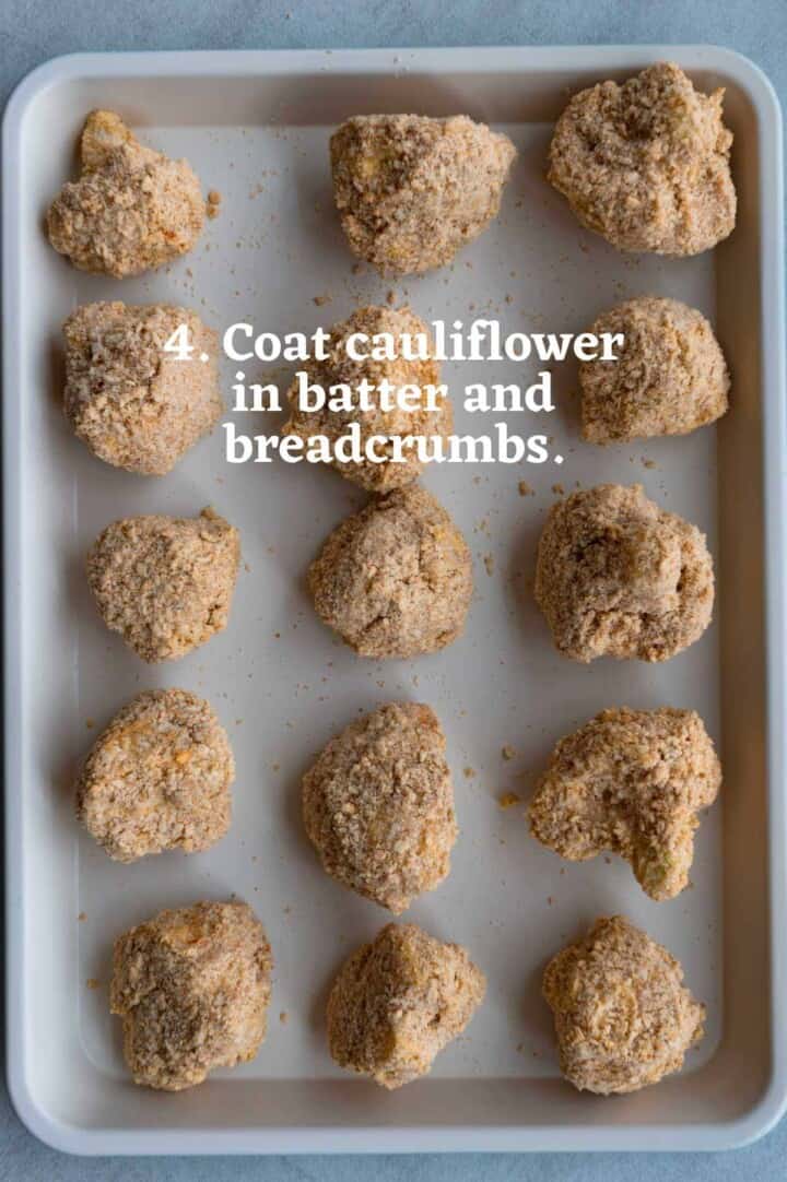 Breaded cauliflower in three rows on a white baking sheet.