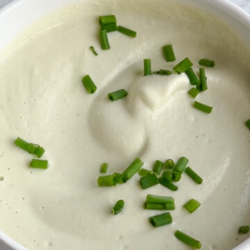 Creamy garlic sauce garnished with chopped chives.
