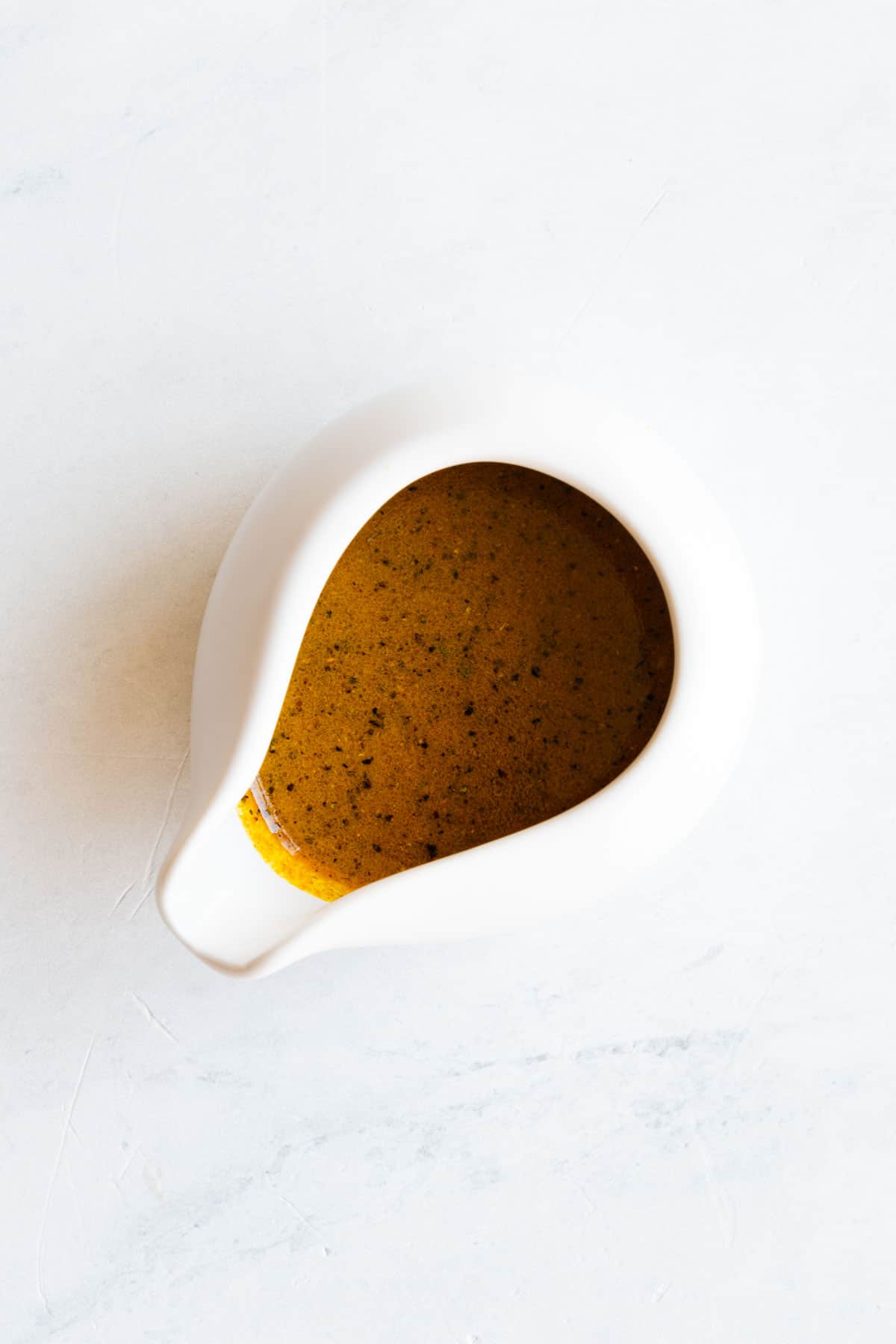 Curry dressing in a white pourer.