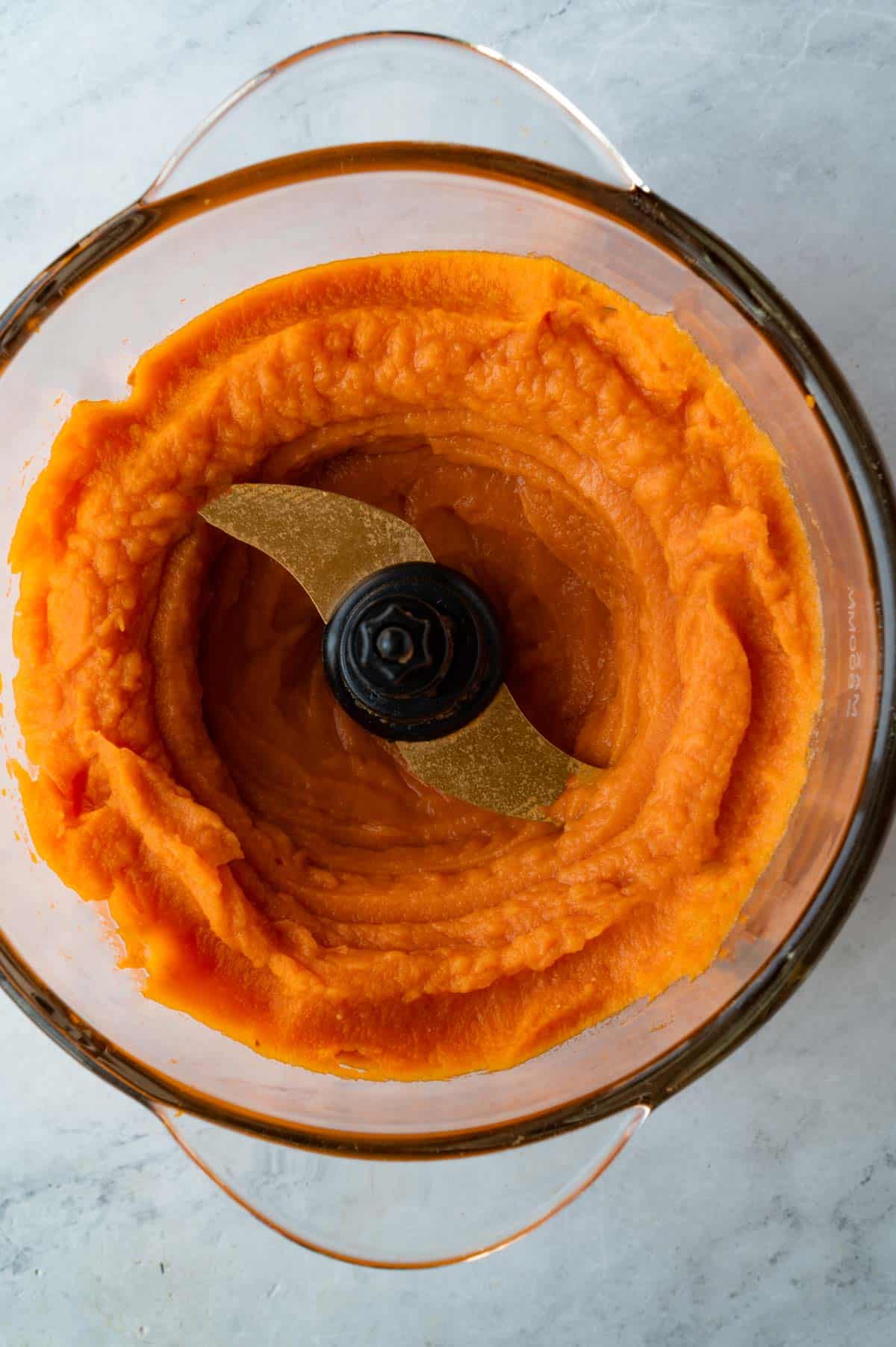 Pureed sweet potato with miso in a glass canister of a food processor.
