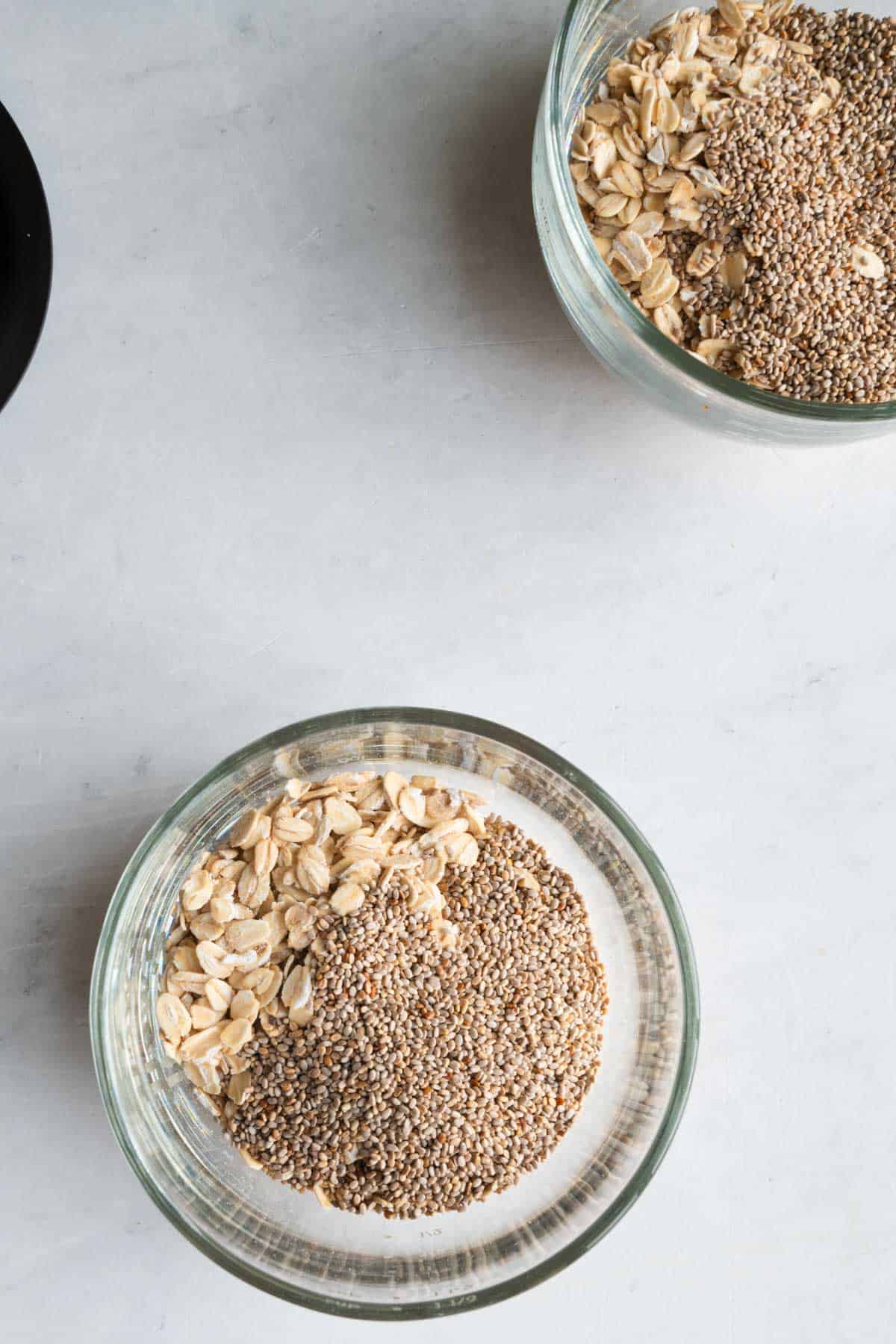 Two glass containers with oats and chia seeds.