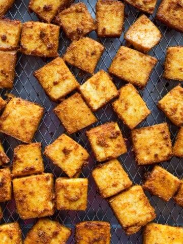 Crispy tofu cubes on a wire rack.