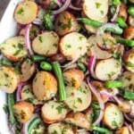Vegan German Potato Salad with dill, parsley, red onion, Dijon, olive oil, red baby potatoes, and green beans.