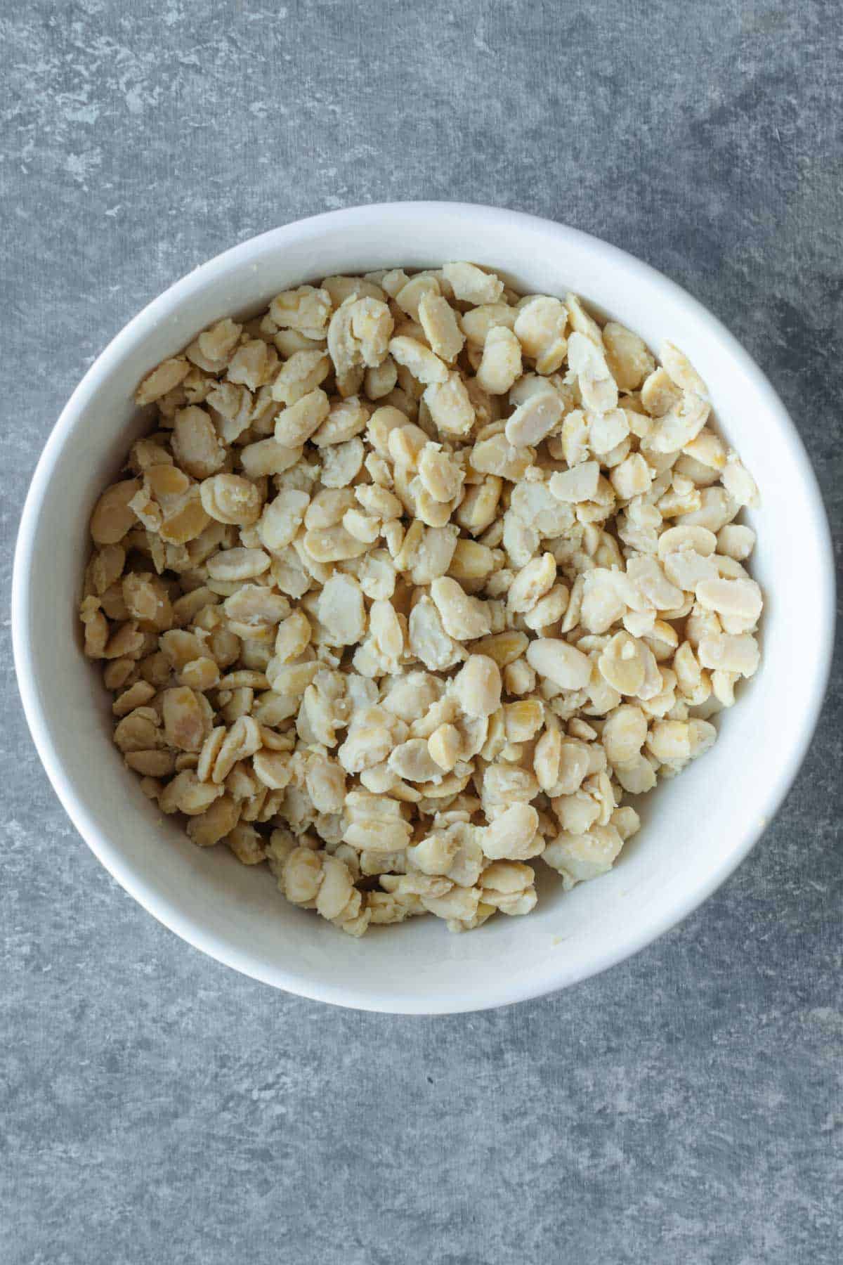 Crumbled tempeh in a white bowl.