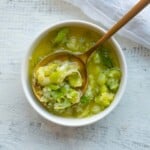 Ginger scallion sauce in a white bowl with a gold spoon.