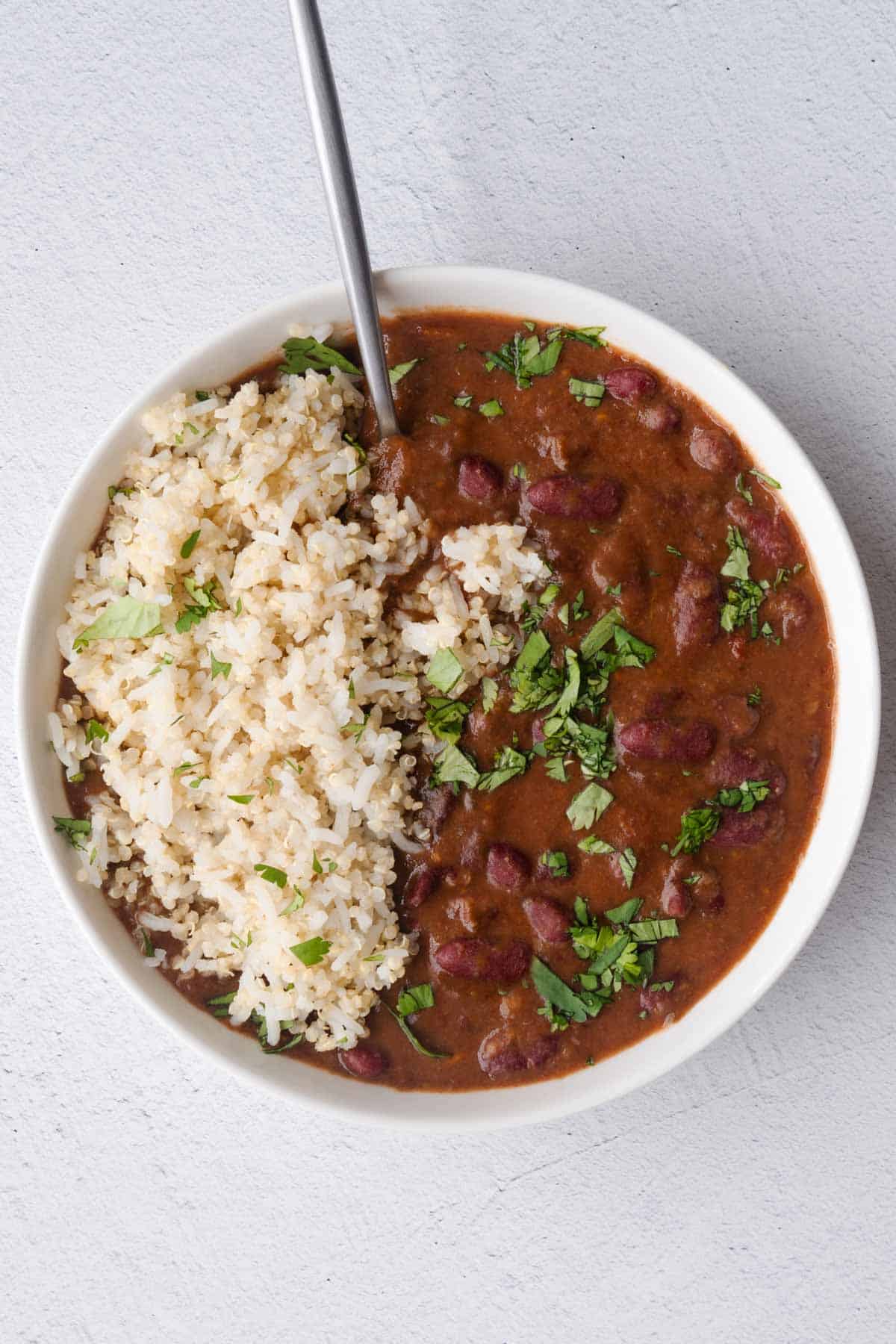 Vegan red bean and rice in a white bowl with chopped cilantro.