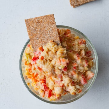 Chickpea mash in a glass bowl with whole grain crackers.