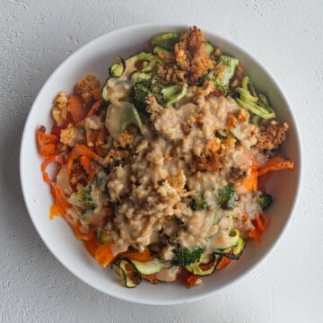 Health salad with crispy tofu, roasted zucchini, roasted carrot, roasted broccoli, and miso tahini dressing.