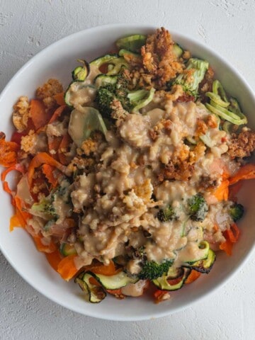 Health salad with crispy tofu, roasted zucchini, roasted carrot, roasted broccoli, and miso tahini dressing.