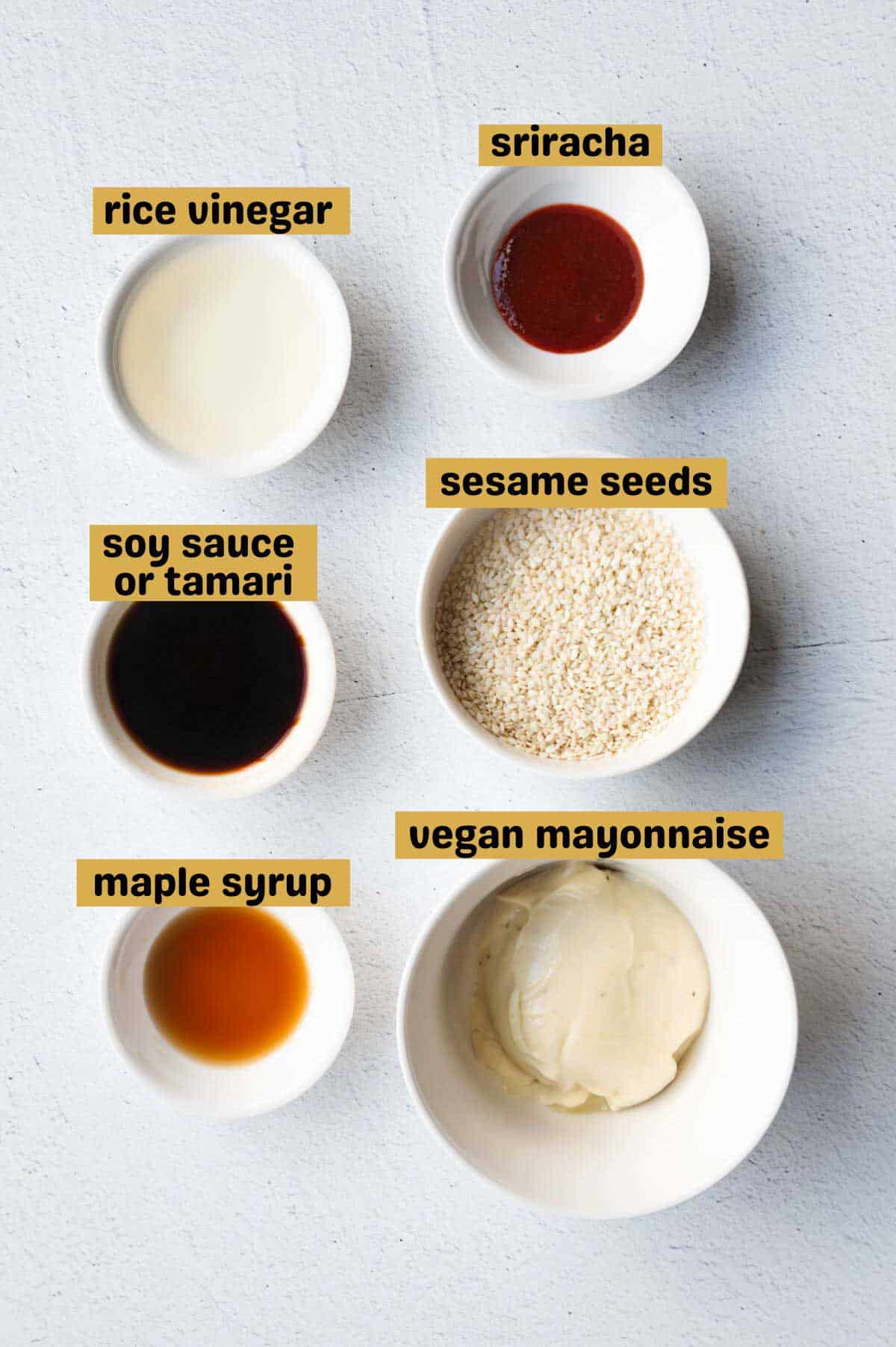Sriracha, rice vinegar, sesame seeds, soy sauce, vegan mayonnaise, and maple syrup in white bowls.