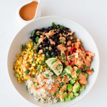 Baja bowl with rice, quinoa, avocado, tomatoes, black beans, corn, lime, and Bala sauce.