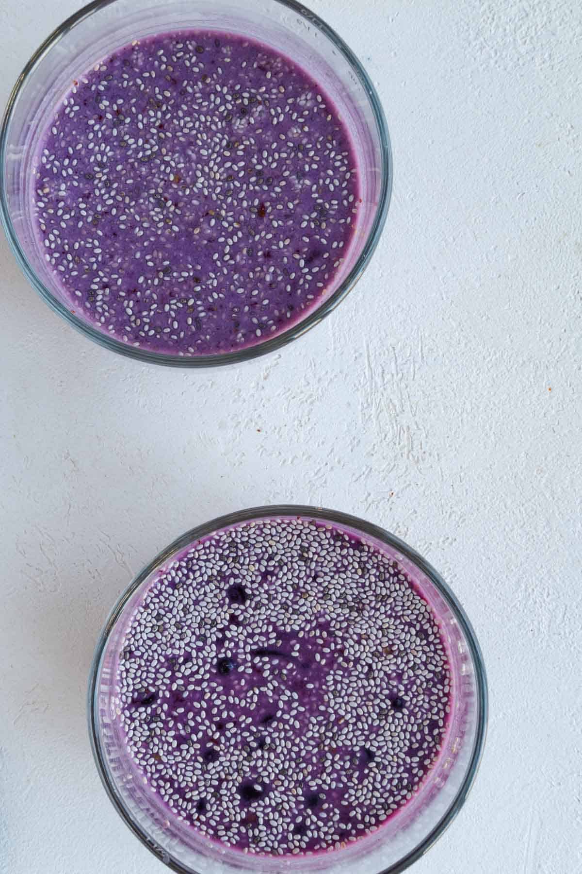 Berry chia pudding in two glass containers.