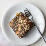 Slice of buckwheat banana bread on a white plate with a silver fork.