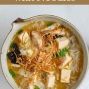 Miso soup with noodles, mushrooms, tofu, nori seaweed, and green onion.