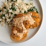 Three golden crispy vegan patties with chipotle sauce served on rice with kale.