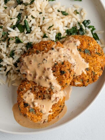 Three golden crispy vegan patties with chipotle sauce served on rice with kale.