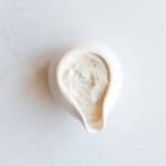 Dairy-free tahini yogurt sauce in a white bowl.