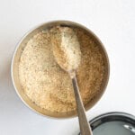 Homemade protein powder in a white container with a spoon.