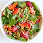 Strawberry salad with baby kale, capers, sesame seeds, red onion, edamame, buckwheat, and balsamic dressing.