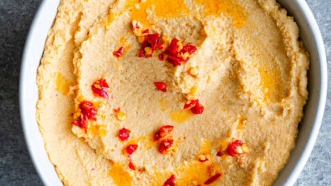 Artichoke hummus with Calabrian chili peppers in a white bowl.