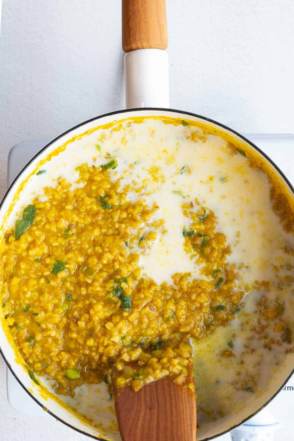 High-protein savory oatmeal and nondairy milk in a saucepan.