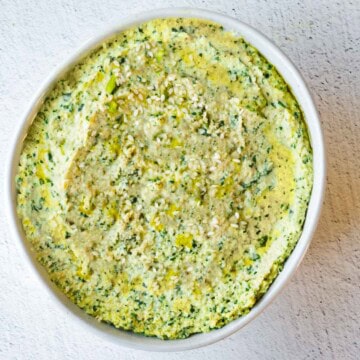 Dairy free cream cheese with artichokes in a white bowl.