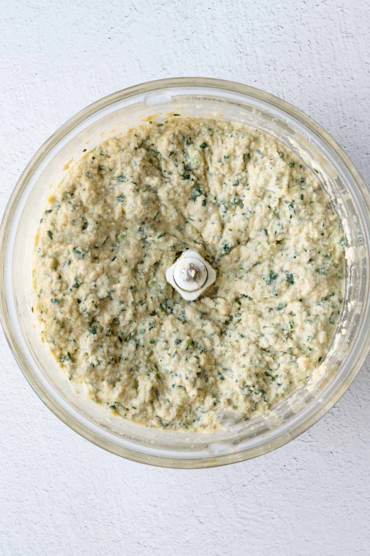 Blended High-Protein Vegan Artichoke Dip in the canister of a food processor.