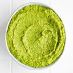 Green pea hummus in a white bowl.