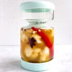 Cauliflower florets in a pickle jar with black cumin seeds, star anise, cinnamon, red chili pepper, freeze dried ginger, black peppercorns, and apple cider vinegar.