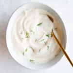 Tofu sour cream in a white bowl with dill.