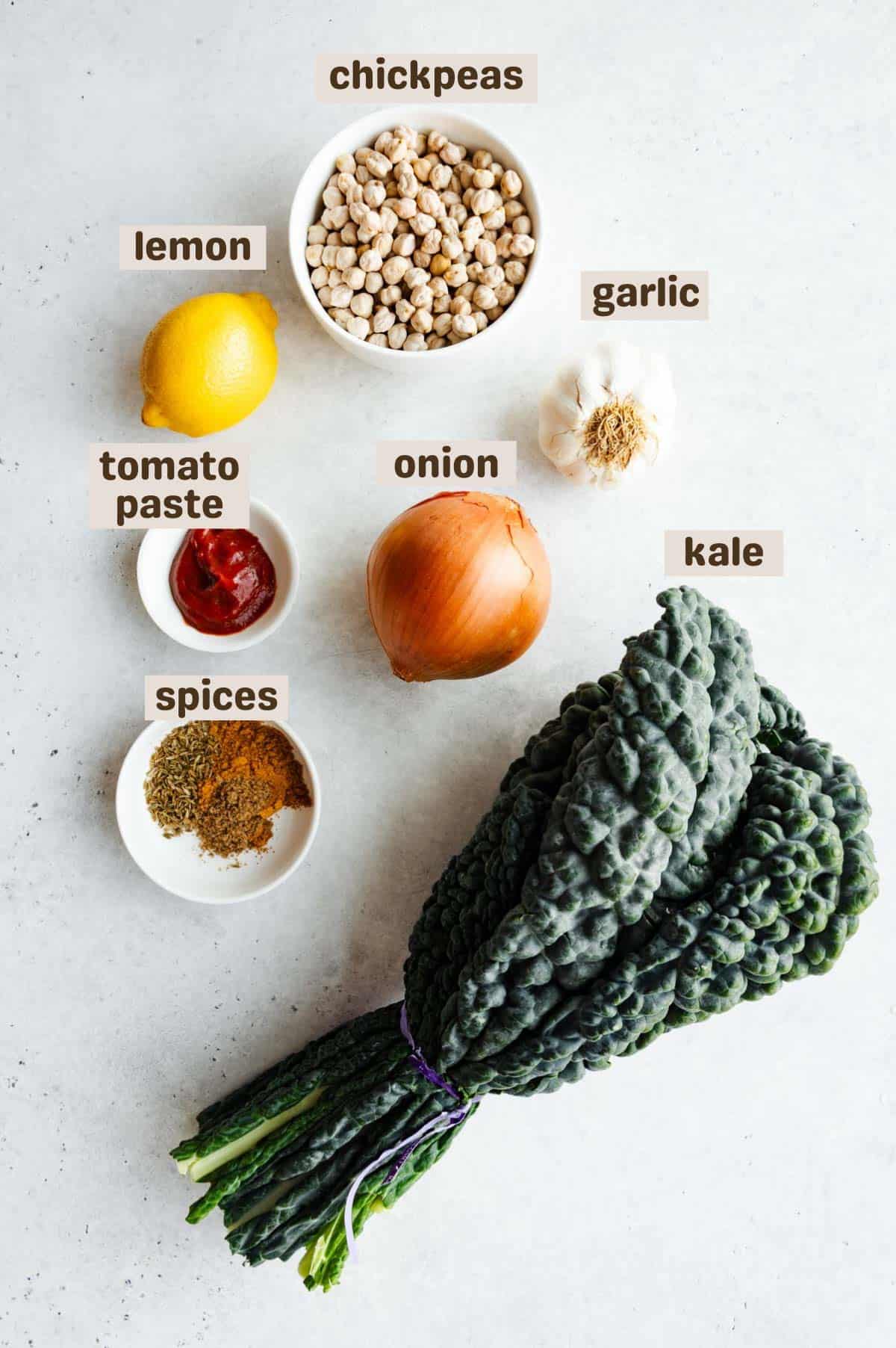 Indian chickpeas ingredients: chickpeas, lemon, kale, onion, garlic, tomato paste, and spices.