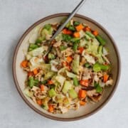 Microwave hot pot in a bowl with tofu, Bok choy, carrot, cabbage, mushrooms, green beans, green cabbage, and miso broth.