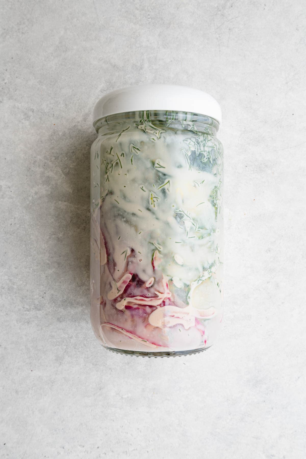 Creamy cucumber salad in a jar for meal prep.