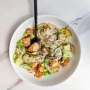 High-Protein Creamy Cucumber Tofu salad in a white bowl with a fork.