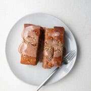 Protein banana bread on a white plate with a silver fork.