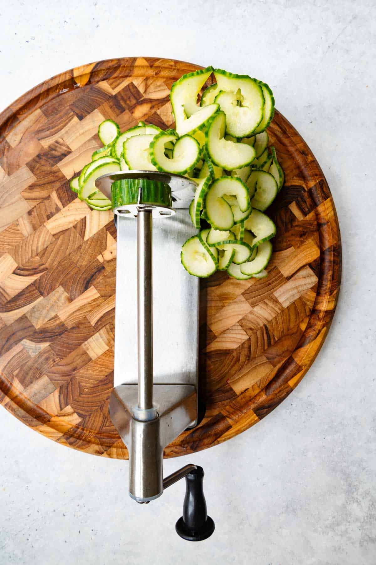 Cucumber being cut with a spiralizer.