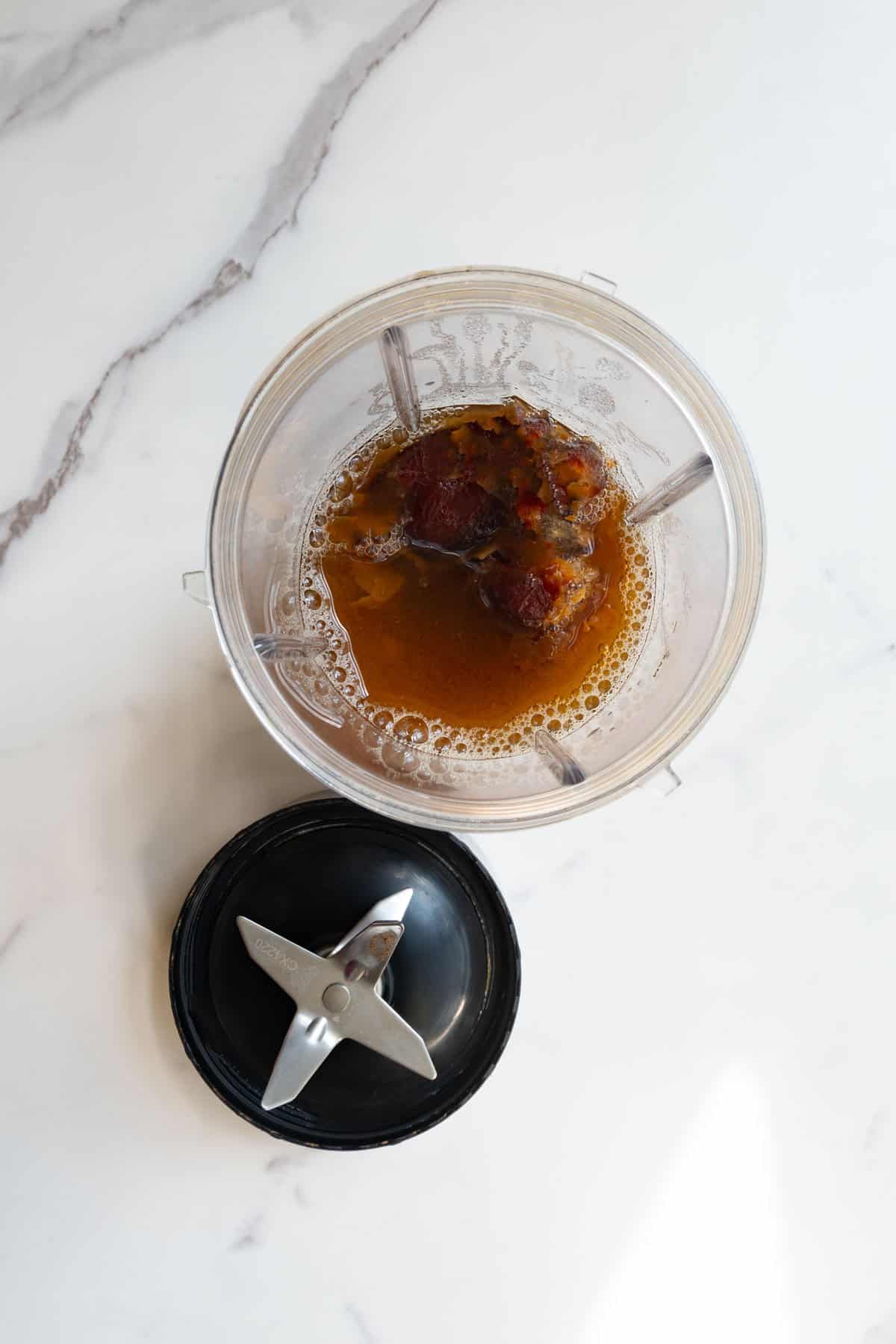 Soaked dates and water in the canister of a blender.