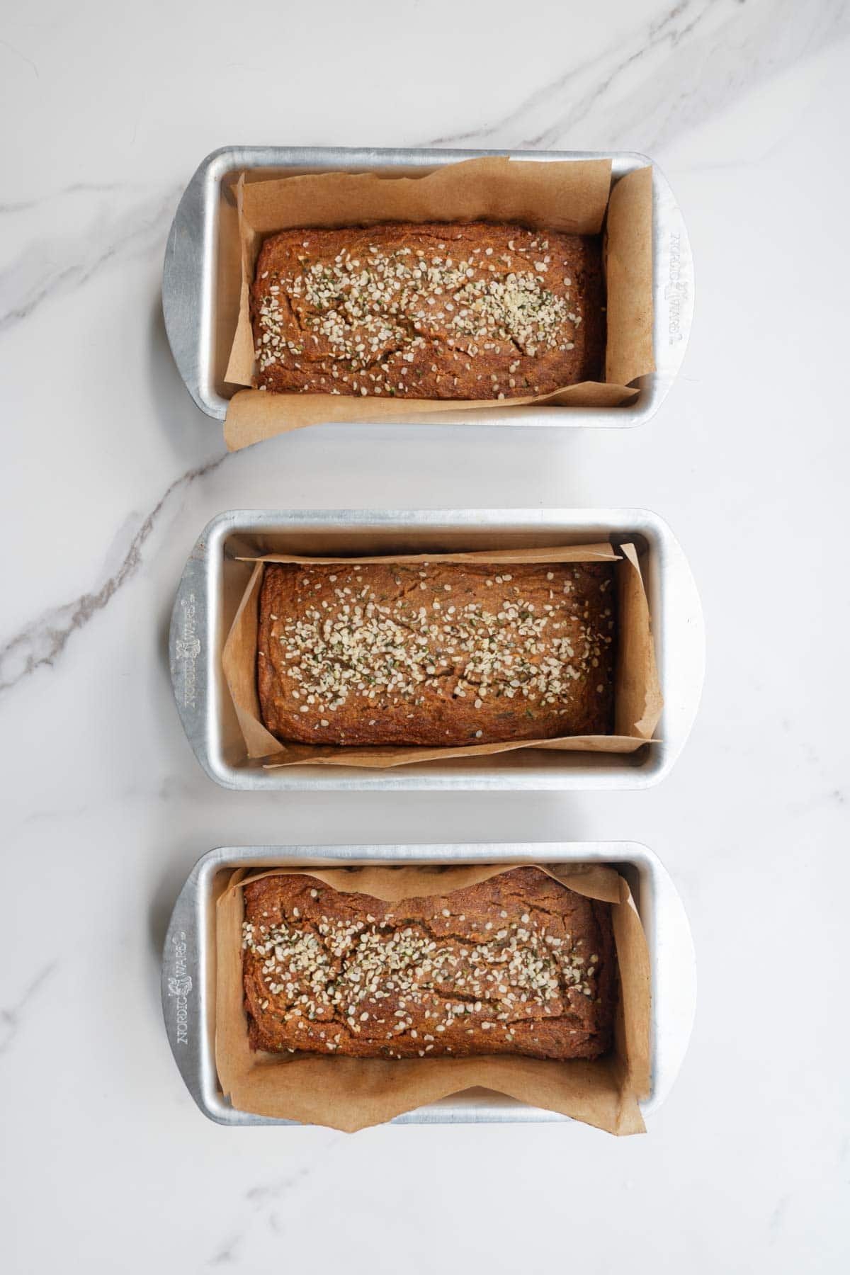 Three mini loaf pans with gluten-free zucchini bread.