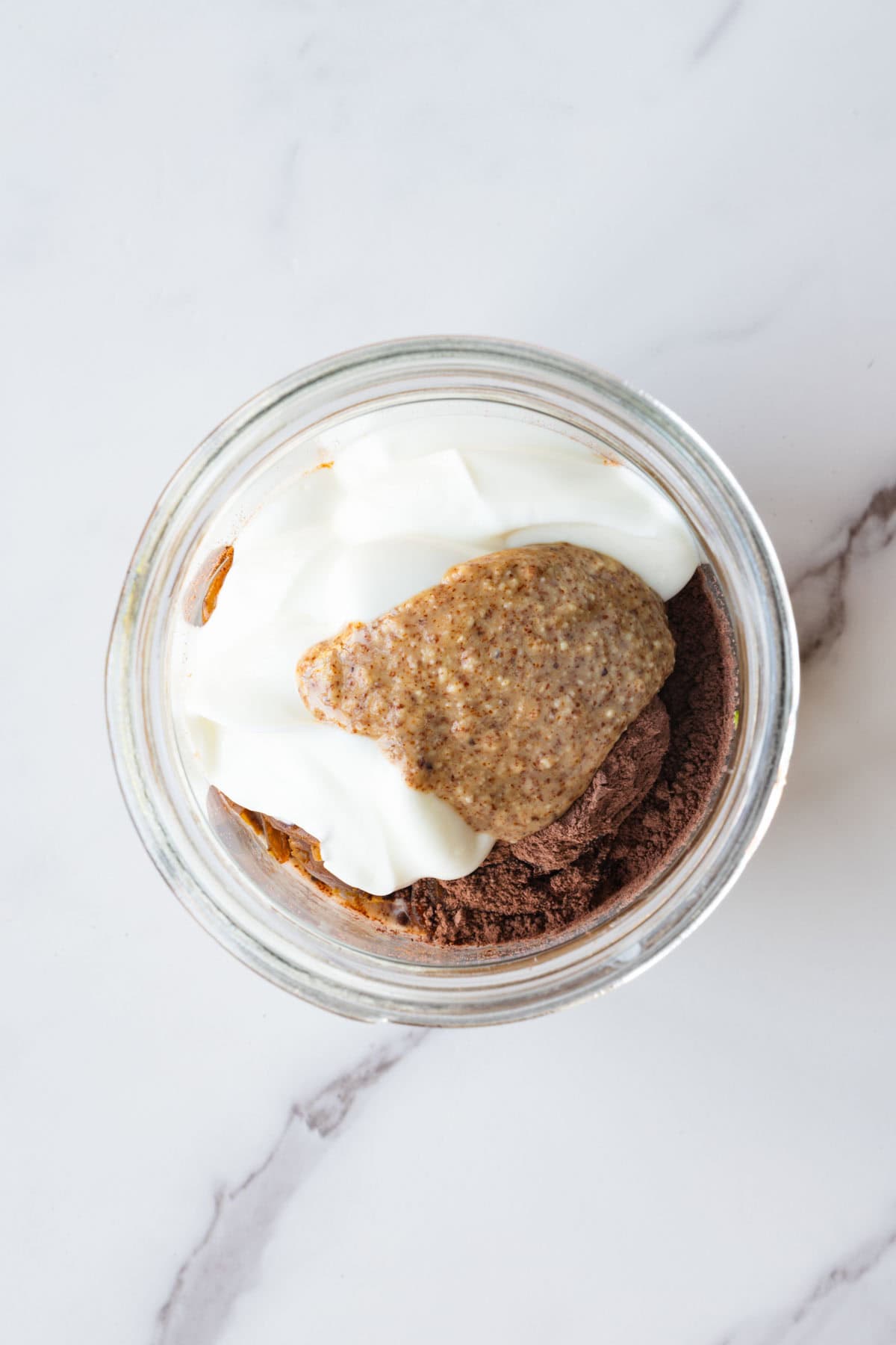Ingredients for zucchini pudding in a glass jar.