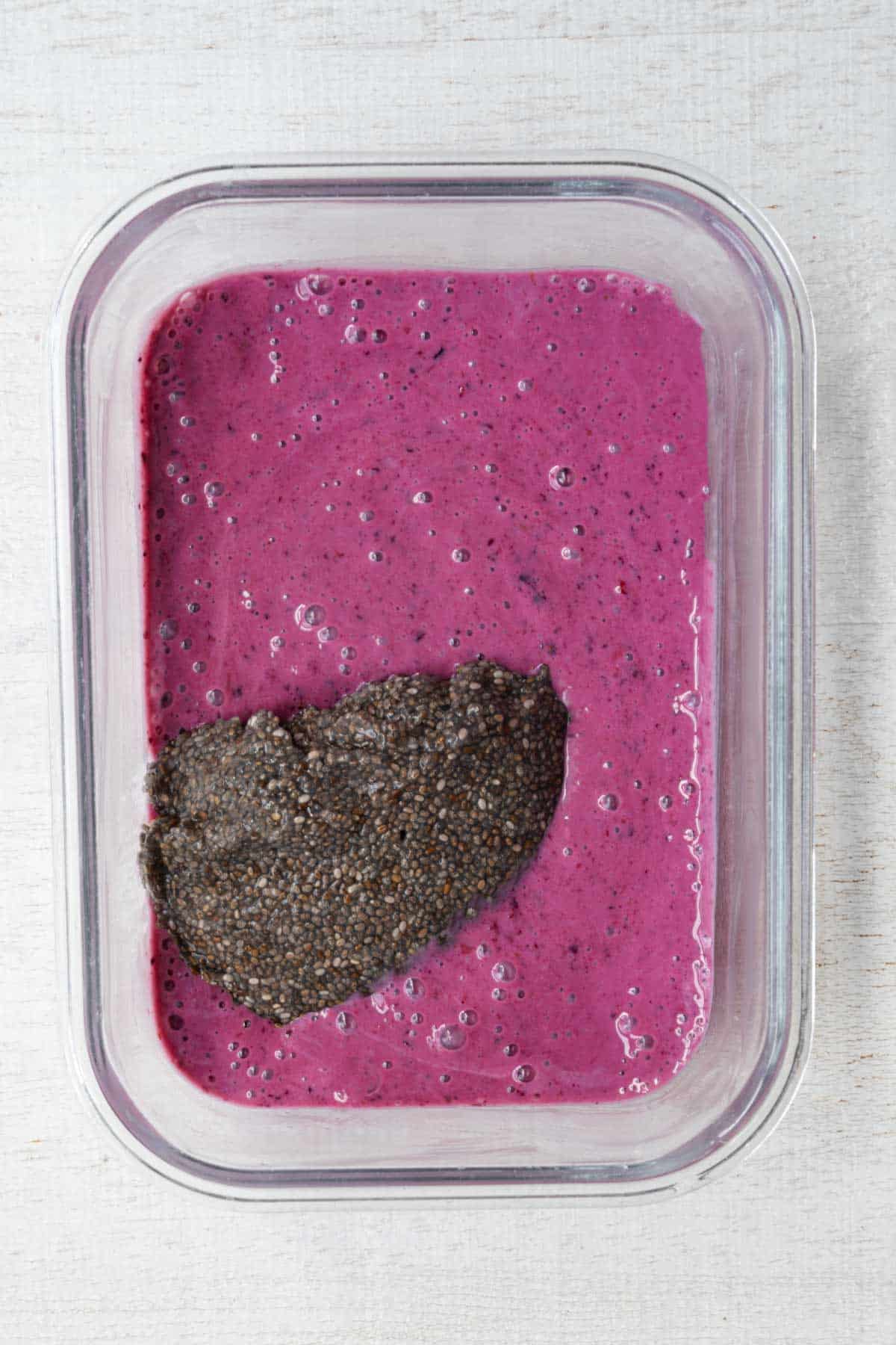 Soaked chia seeds added to pink blended mixture.