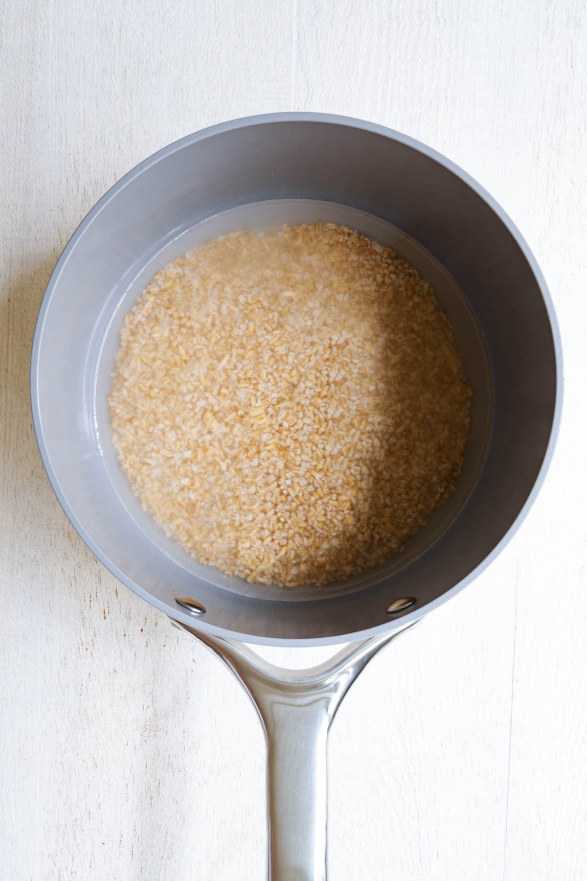 Steel-cut oats in a saucepan with water.