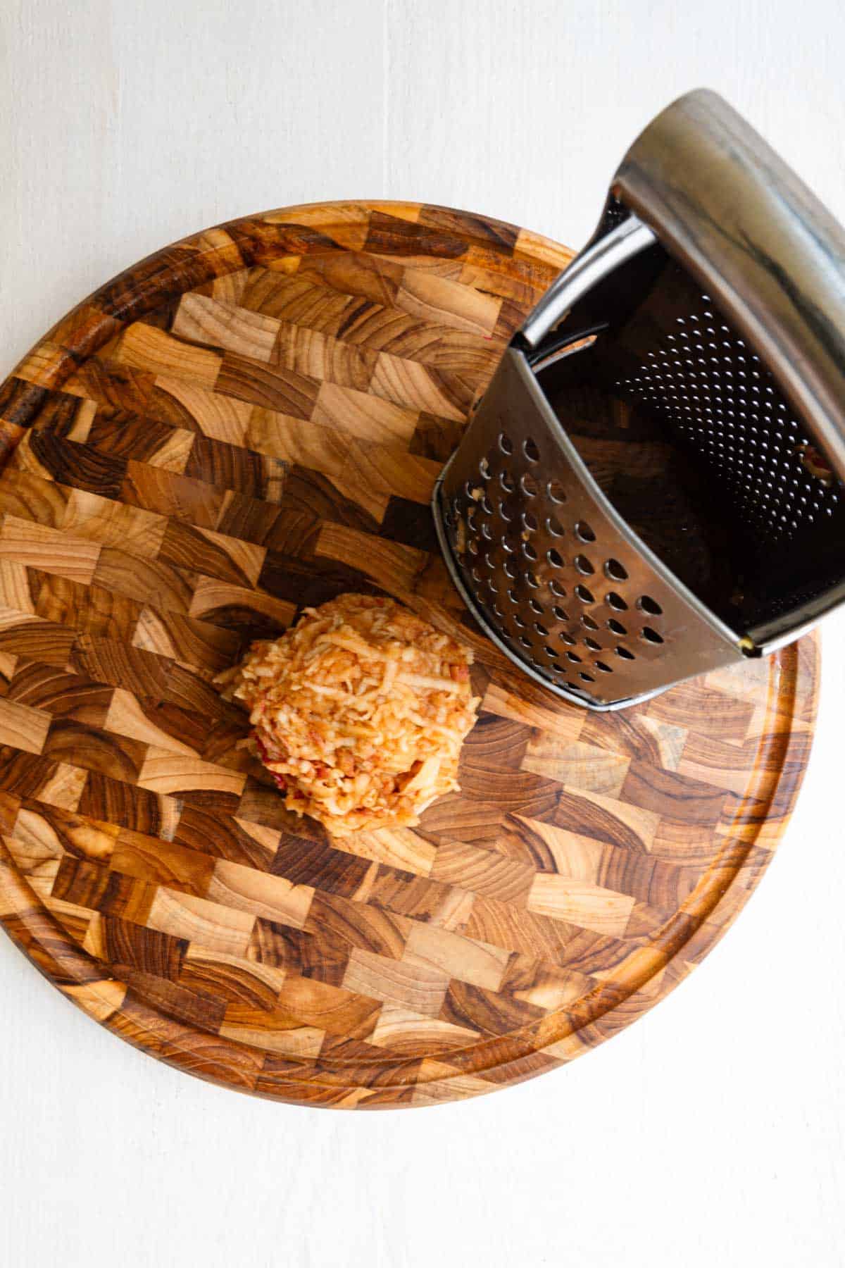 Grated apple on a wooden cutting board.