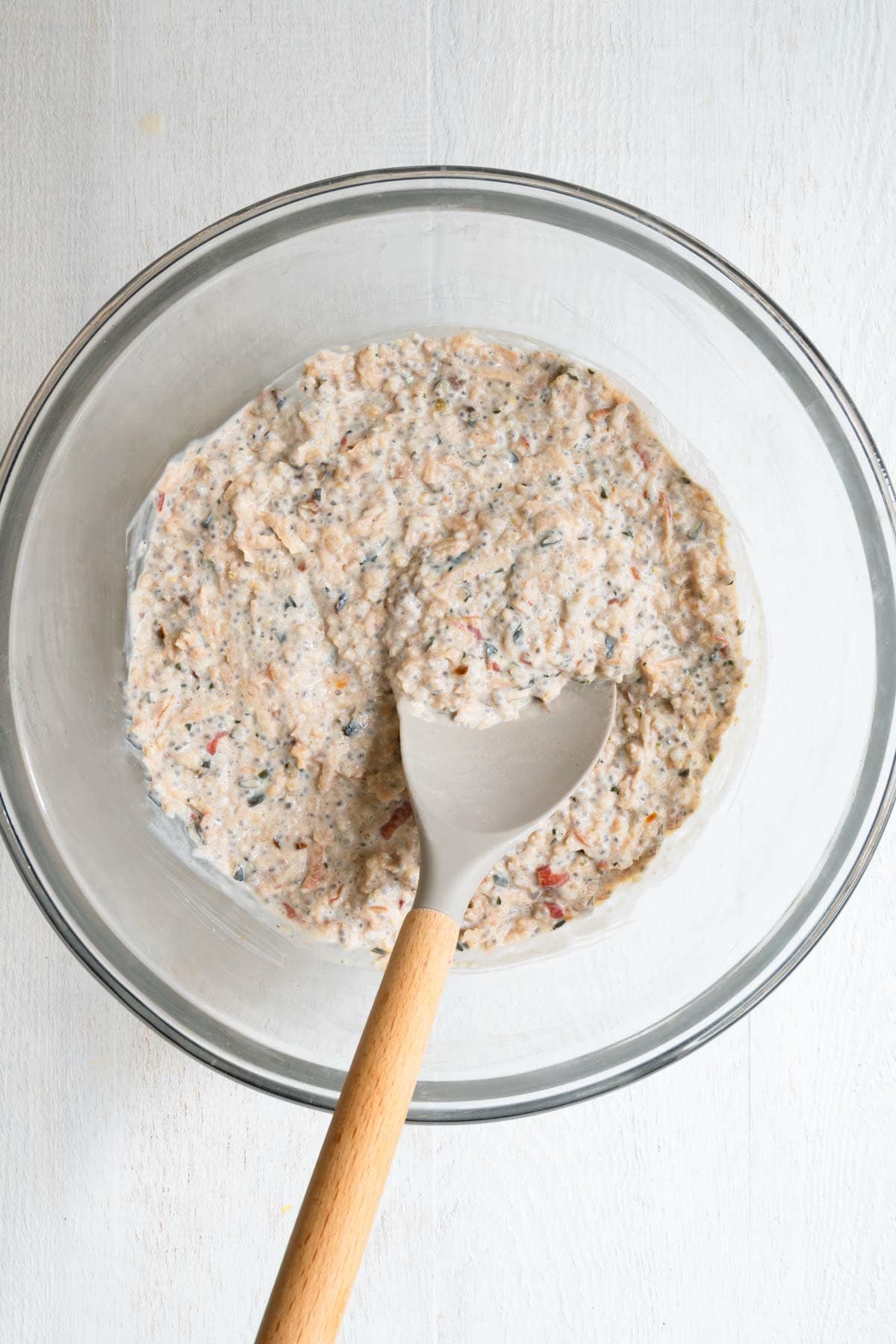 High-protein apple cinnamon chia seed oatmeal in a large bowl with a spatula.
